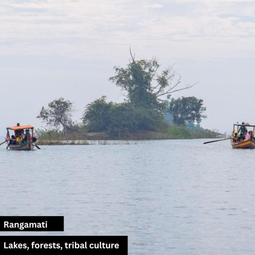 A peaceful view of Rangamati Lake in Bangladesh with two boats floating on the calm water. In the middle of the lake, a small island is visible with green bushes and natural vegetation. The scenic beauty reflects the serene charm of Rangamati’s landscape.